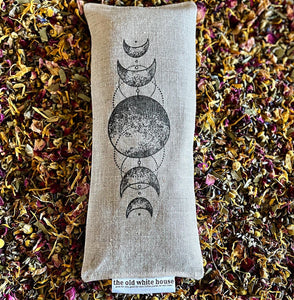 goddess eye pillow filled with a blend of rose petals, chamomile, calendula, lavender, hibiscus, and eucalyptus, and hand stamped with phases of the moon on both the eye pillow and matching bag. 